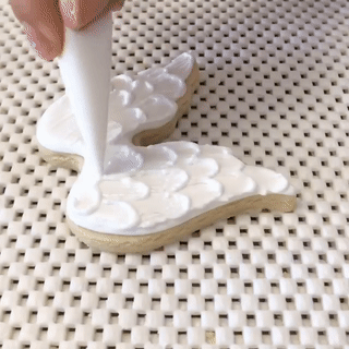 A peach-colored food mixture being placed into a bunny-shaped mold